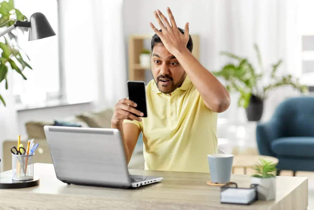 Man holding phone and frustrated with call from disconnected number.