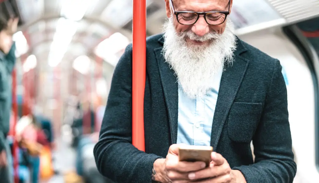 Man on a train using his smartphone now using good habits after he performed a factory reset
