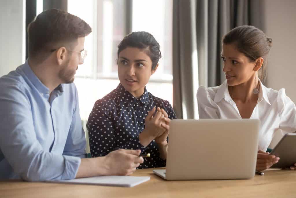 Woman with great soft skills directing her two coworkers at her cyber security job