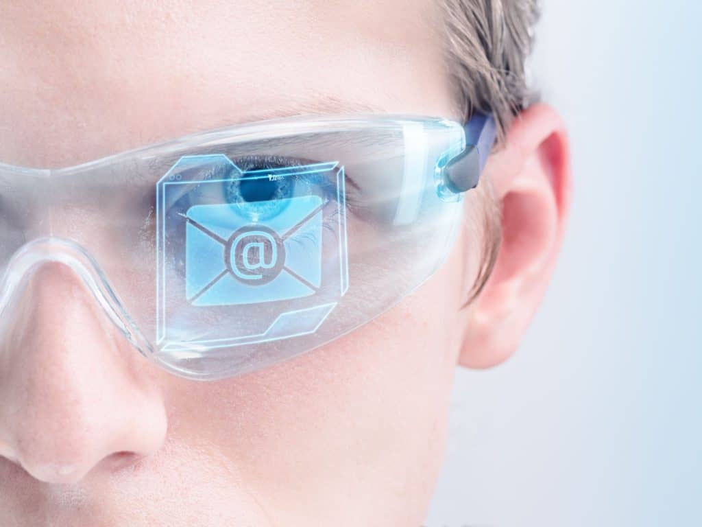 Close-up of man's face wearing goggles with reflection of email which has a pdf that might contain a virus