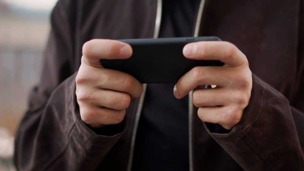 Close up of gamer playing on smartphone which is hot damaging the phone battery