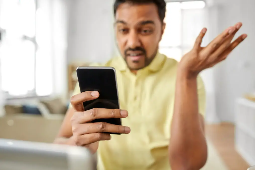 Man with smartphone confused by a call from disconnected number