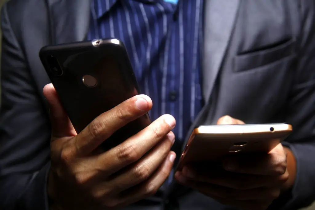 Close up of businessman's hands holding a personal phone and a work phone