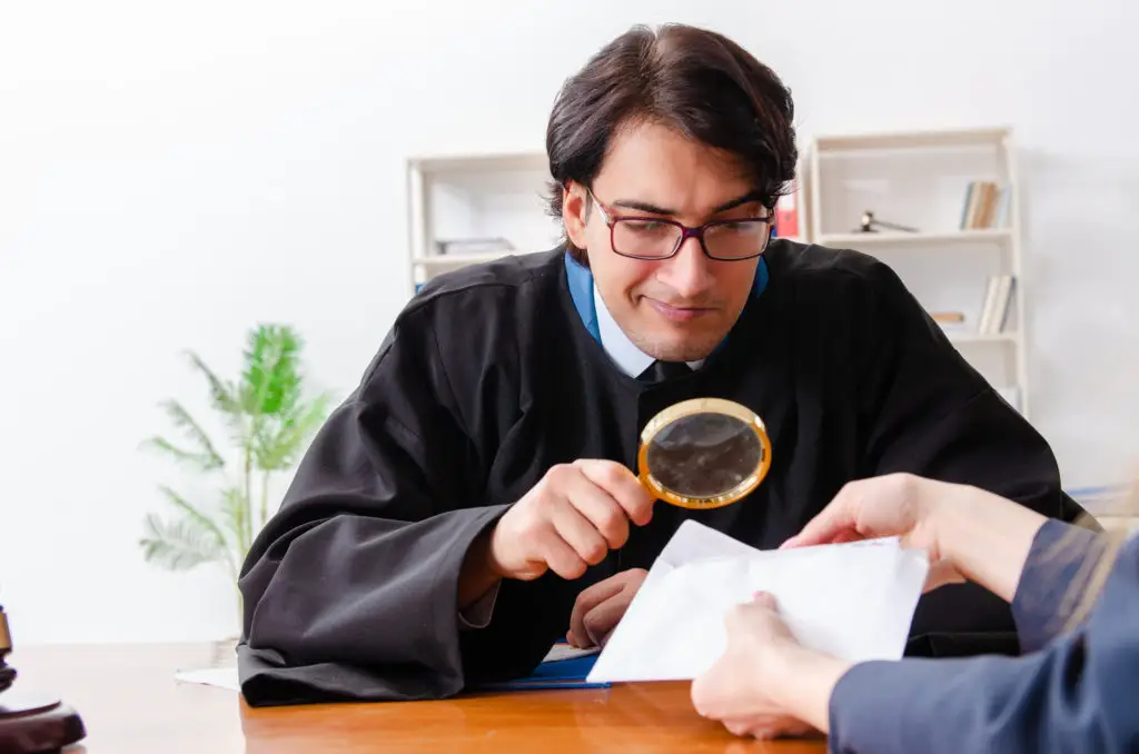 Lawyer with magnifying glass inspecting envelope helping to track fake email