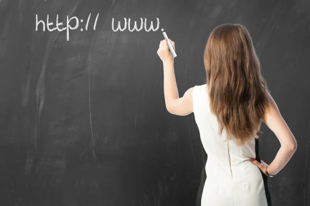 Woman at chalkboard teaching how to read a web address or url.