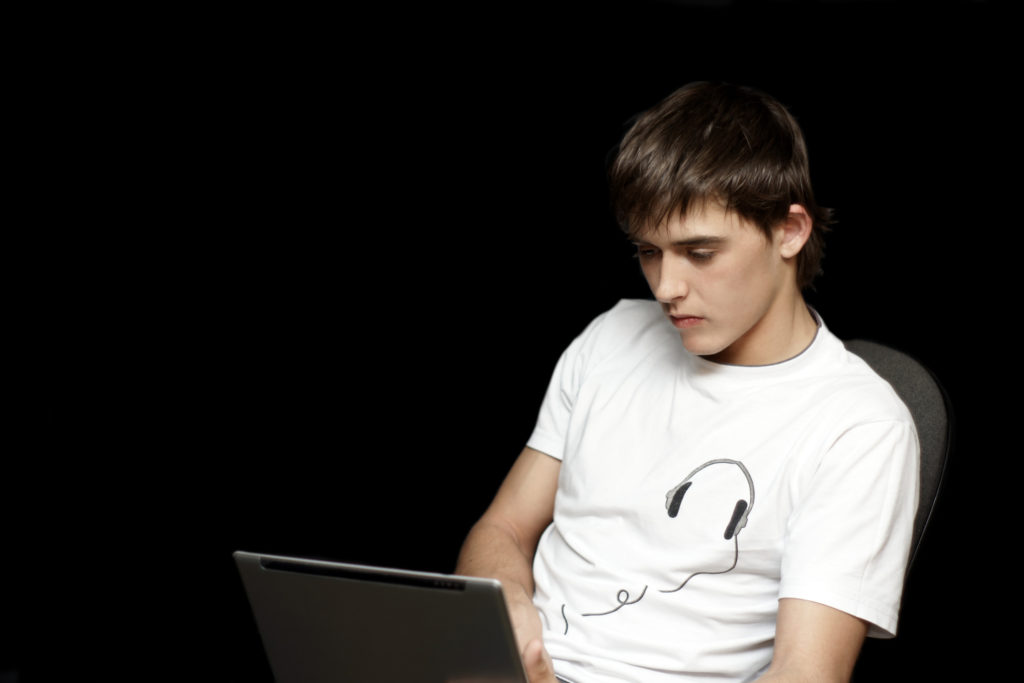 Teenager using a laptop watching youtube advert-free