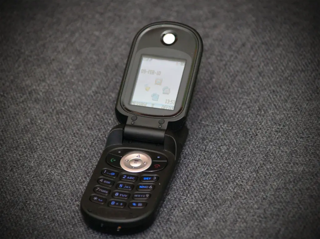 Small, black burner flip phone.