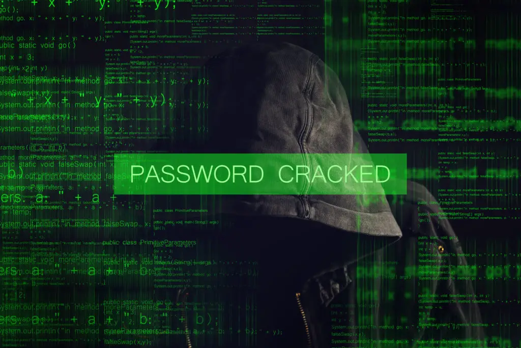 Password cracked by faceless hooded anonymous computer hacker with programming code.