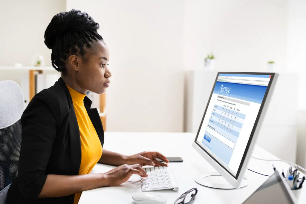 Woman filling in an online survey on a laptop.