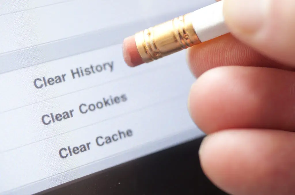 Person using a pencil eraser to point at options for clearing history, cookies, or cache.