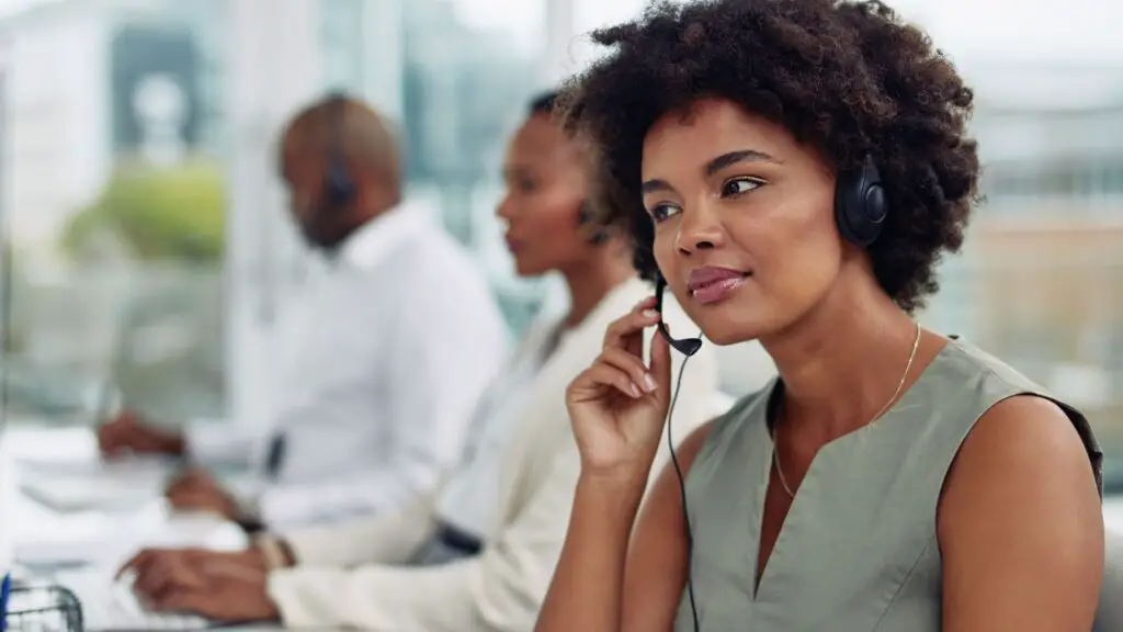 Woman working in help desk listening carefully to customer problem