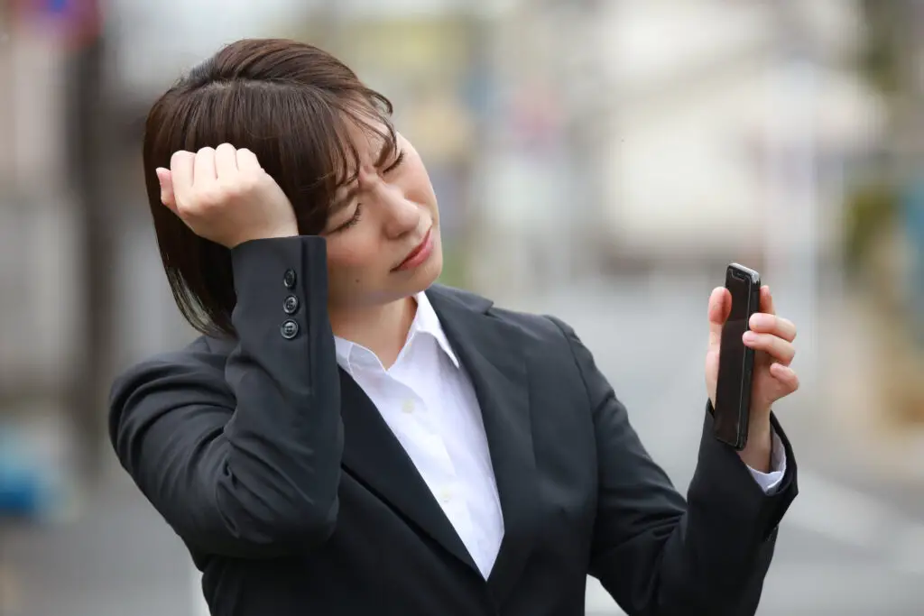 Sad woman holding a dead smartphone which is a sign of being hacked