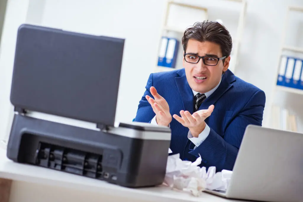 Frustrated business man with laptop and printer trying to figure out how to print encrypted email.