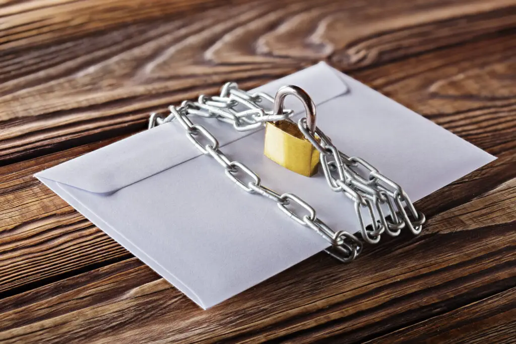 Padlock and chain wrapped around envelope concept to keep someone from hacking email without a password.