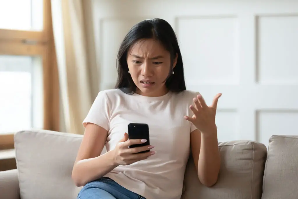 Woman with smartphone, angry that she's getting texts from gmail accounts